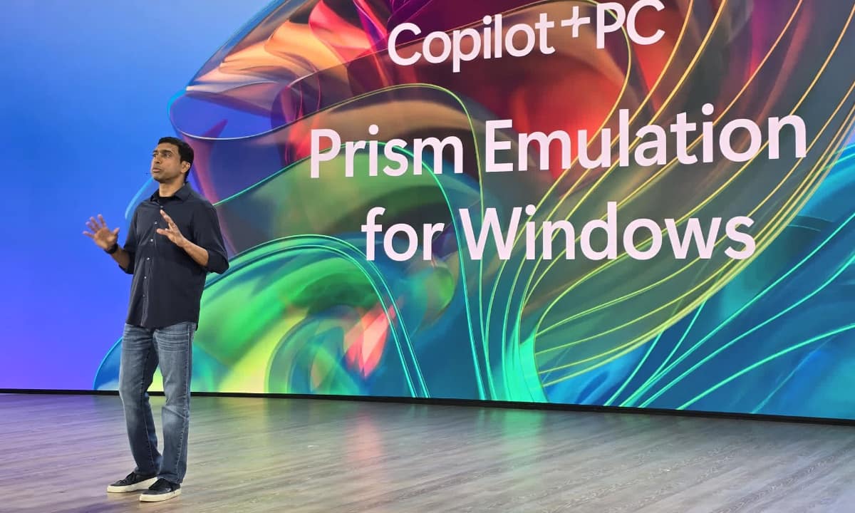 Image of a Microsoft representative presenting Microsoft Prism emulation on stage.