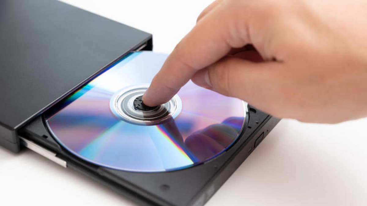 Image of someone putting a CD into the PC